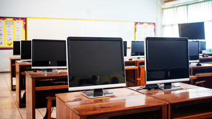 Computers on wooden table in room for education