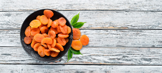 Dried apricots on a white wooden background. Dried fruit Top view. Free space for your text.