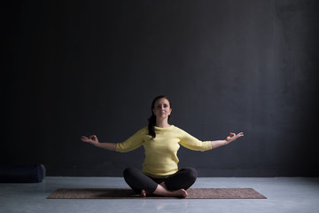 Obraz premium Young woman practicing yoga, sitting on meditation