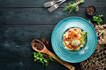 Pasta with pineapple and carrots. In the plate. Top view. Free space for your text. Rustic style.