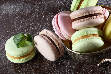 Macaroons cakes on a brown homemade background, top view on a brown background. Still life concept