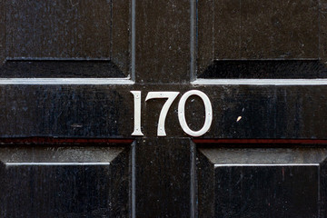 House number 170 with the one hundred and seventy in silver on the middle cross frame of a panelled...