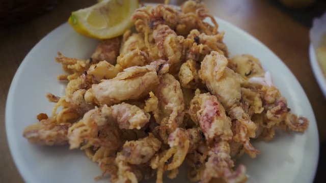 Spanish tapas: Plate of deep fried squids or Chipirones with lemon. Typical spanish food