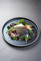 Gebratenes Dänisches Skrei Kabeljau Fisch Filet mit Steinpilzen und Salat als closeup auf einem...