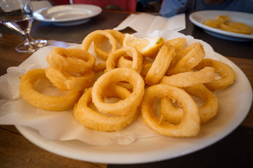 Spanish tapas: Plate of Roman-style squid or fried calamari with lemon. Typical spanish food
