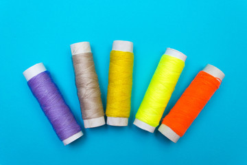 Colored sewing thread on a blue background