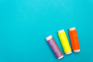 Colored sewing thread on a blue background