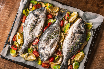 mother cooks dinner for the whole family, bakes dorado fish