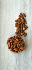 Healthy food  for background image close up almond nuts. Texture on white grey table top view. Nut on the cup plate