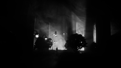 Obraz premium Artwork decoration. A man standing on a road of burnt up city. Apocalyptic view of city downtown as disaster film poster concept. Night scene. City destroyed by war.