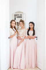 Naklejka premium three bridesmaids smiling in a bright room at a wedding