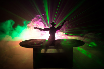 Dj club concept. DJ mixing, and Scratching in a Night Club. Man silhouette on vinyl turntable,...