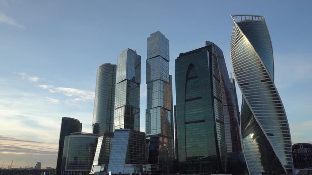 Financial District. Cityscape, in the background, blue sky and beautiful clouds. Office buildings. Frame movement from right to left with stops and in the opposite direction. Daytime