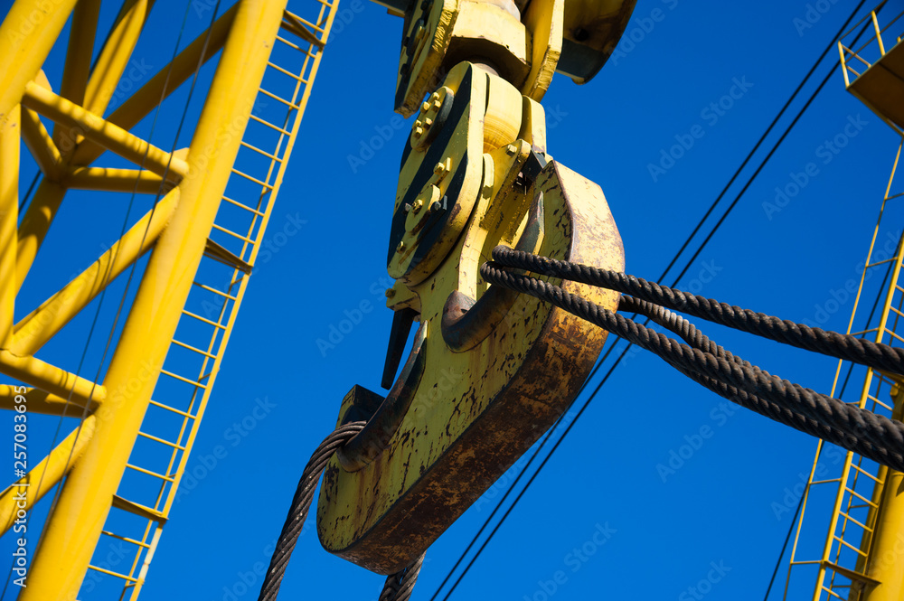 Wall mural Loading in port. Floating port crane on blue sky background