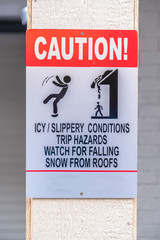 Caution sign on slippery and snowy area in winter