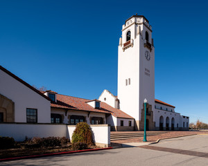 Classic Spanish style train depot with clock and blue sky