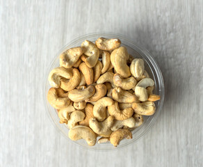 Healthy food  for background image close up cashew nuts.  Nuts texture on white grey table top view on the cup plate