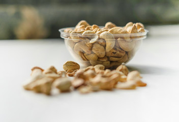 Healthy food  for background image close up cashew nuts.  Nuts texture on white grey table top view on the cup plate