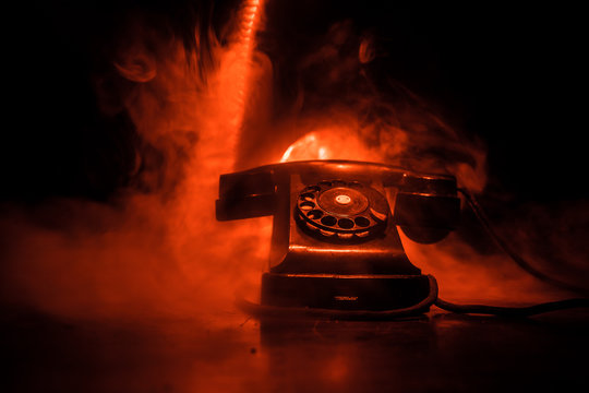 old black telephone on old wood plank with art dark background with fog and toned light. empty space