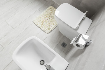 White ceramic bidet and toilet at luxury bathroom interior