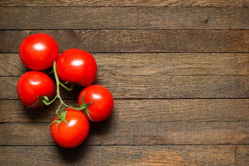 Red ripened tomatoes on wooden table with copy space