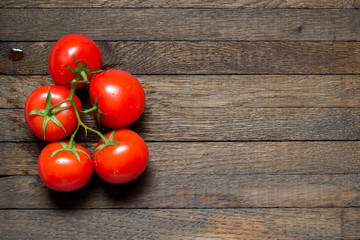 Red washed tomatoes on wooden background with copy space