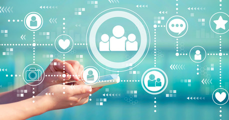 Social media with person holding a white smartphone