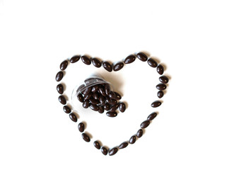Nuts arranged in heart shape on background. Food image close up candy, chocolate milk, extra dark almond nuts. Love Texture on white grey table top view