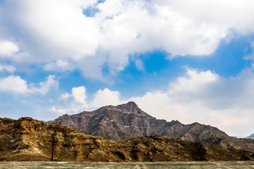 Geological landscape of Jabal Jais characterised by dry and rocky mountains, Road between mud mountains in Ras Al Khaimah, United Arab Emirates