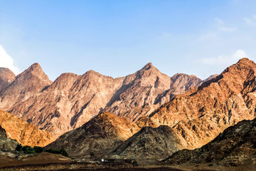 Fototapeta na wymiar Geological landscape of Jabal Jais characterised by dry and rocky mountains, Road between mud mountains in Ras Al Khaimah, United Arab Emirates
