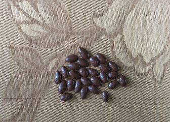 Food image close up candy, chocolate milk, extra dark almond nuts. Texture on top view background