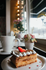 Millefeuille Napoleon with coffee in cafe. Exquisite dessert with fresh berries on white background. French Vanilla Raspberry Mille-feuille on the dish