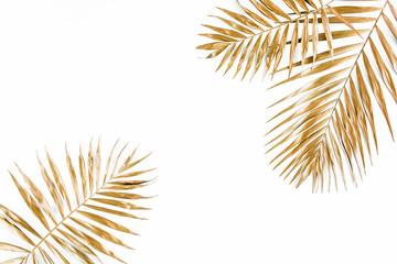 Fototapeta premium Gold tropical palm leaves on white background. Flat lay, top view minimal concept.