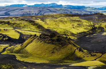 First craters of Southwestern part of Lakagigar volcanic fissure from Laki volcano in South of Iceland. Green-yellow colored Icelandic moss contrasted with black volcanic lava rocks.