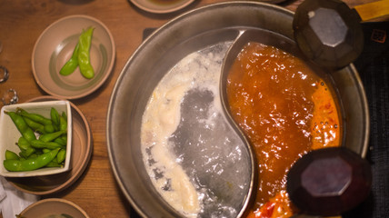 Shabu shabu hotpot dipping sauce serving with side dishes on wood table