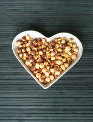 Nuts arranged in heart  on background. Healthy Food image close up hazelnuts. Love Texture on top view