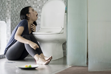 Fototapeta na wymiar Skinny woman vomiting after eating
