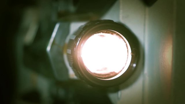 Vintage Movie Projector Turning On with Light Beam in Dark Room