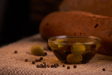 fresh bread baguette with olive oil, olives. cheese and rosemary on wooden background. Teasty breakfast