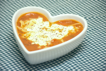 Tomato and cheese soup in heart shaped bowl.
