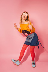 Retro style fashionable woman with vintage vinyl on pink background