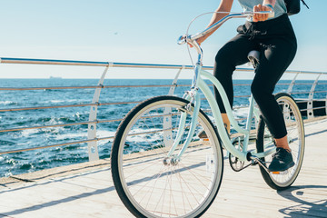 Young woman riding vintage bike along the waterfront