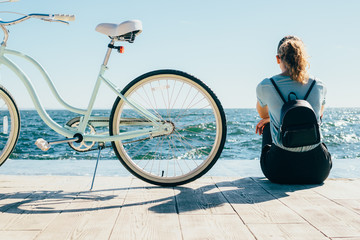 Female wearing backpack resting after bike ride