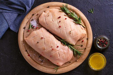 Raw uncooked poultry meat cut on wooden tray. Duck breasts with honey, rosemary and spices.