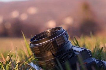 Fototapeta Stary aparat analogowy leżący w trawie na tle gór obraz