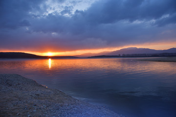 Beautiful sunset.Sun,sky,lake.Sunrise landscape, panorama of beautiful nature.Sky with amazing colorful clouds.Water reflections.Magic Artistic Wallpaper.Dream, line.Creative Blue Background.