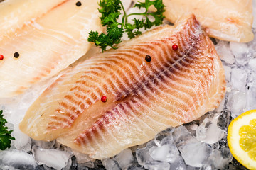 Whitefish Tilapia Fish Raw Fillet on Ice. Selective focus.