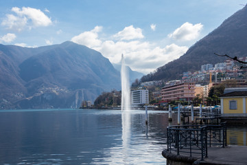 Fototapeta na wymiar Lugano, Switzerland - March 10, 2019: A view of central Lugano with lake and fountain