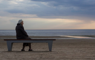 old lonely retired grandmother sitting on a bench