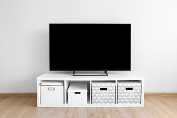 Lcd tv on white shef with boxes in modern room interior
